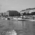 Táncsics oldalkerekes gőzhajó a Bem téri kikötőben, háttérben a rakpart épületei a Dunáról nézve.