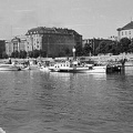 Kőrös oldalkerekes gőzhajó a Bem téri kikötőben, háttérben a rakpart épületei a Dunáról nézve.